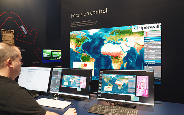 a control room scenario with desktop monitors in front of a large screen