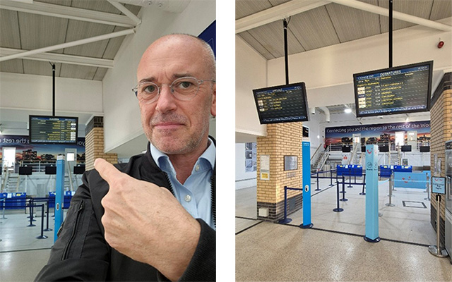 A man points to an information screen in an airport terminal