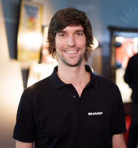 Head and shoulders of a man in a black t-shirt