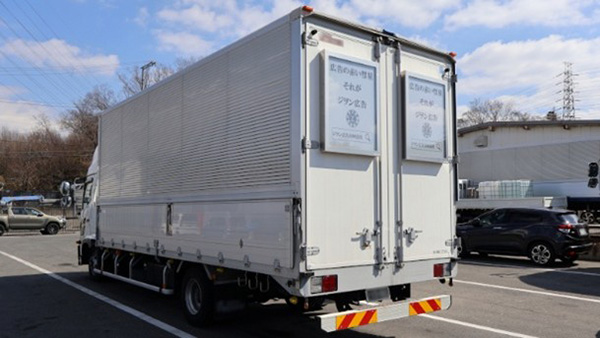 A lorry with two posters on the rear doors
